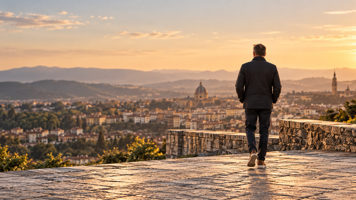 A man walking toward a city overlook at sunset